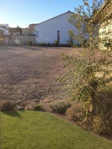 a gravel yard with a white building in the background at le Very Cozy in Albi