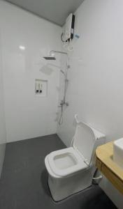 a white bathroom with a toilet and a sink at Sandy Heaven Maldives in Gulhi