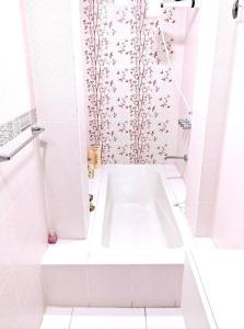 La salle de bains blanche est pourvue d'une baignoire et d'une douche. dans l'établissement Habitación doble con balcón. bonita vista, à Cajamarca