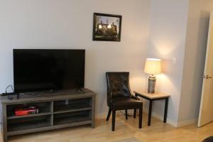 Athens city townhouse, 3 bedroom, 2.5 baths, Wi-Fi في أثينا: غرفة معيشة فيها تلفزيون وكرسي