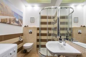 a bathroom with a sink and a toilet and a shower at UrbanNestGroup & Sz 7/20 in Gdańsk