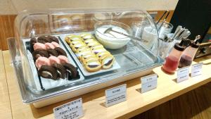 a display of donuts and other pastries on a counter at Dormy Inn Akihabara in Tokyo