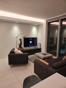 a living room with two couches and a flat screen tv at off 13 in London