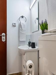 een witte badkamer met een wastafel en een spiegel bij GATEONE AL Airport View House in Machico