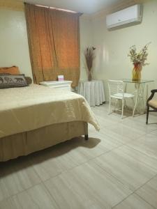 1 dormitorio con 1 cama, mesa y sillas en Alojamiento Cabello de Angel, en Santo Domingo