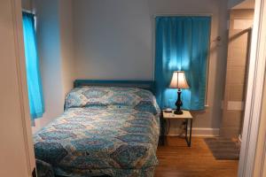 - une chambre avec un lit et une table avec une lampe dans l'établissement 3 Bedroom, 2 Bath, Porch, FREE Wi-Fi, Washer/Dryer, à Athens