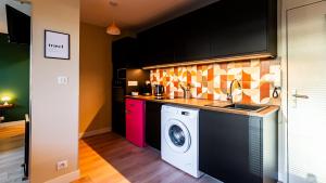 a kitchen with a washing machine and a washer at Le California 70 - suite détente - free parking in Dijon