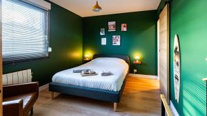 ディジョンにあるLe California 70 - suite détente - free parkingの緑の壁のベッドルーム1室(ベッド1台付)