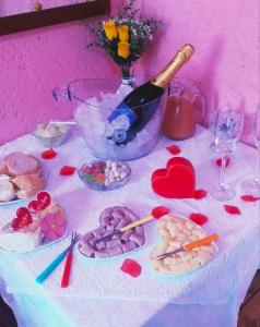 a table with a bottle of wine and valentines cookies at Pousada Shamballah Paranapiacaba in Paranapiacaba +58 photos