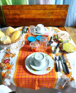 una mesa con un plato de comida y pan. en Pousada Shamballah Paranapiacaba en Paranapiacaba