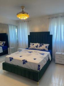 1 dormitorio con 1 cama grande con sábanas azules y blancas en Santiago vista al monumento, en Santiago de los Caballeros