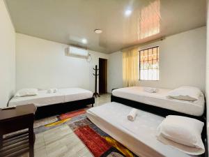 a room with two beds and a window at Alojamiento campestre San Miguel in San José del Guaviare