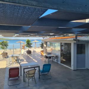 Un patio con mesas y sillas y vista a la playa. en Apartments Lord Pirovac, en Pirovac