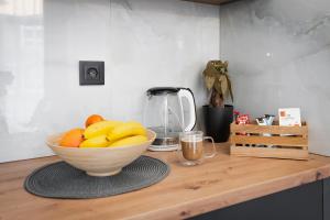 a bowl of bananas on a wooden counter with a blender at Urban city apartment in Visoko