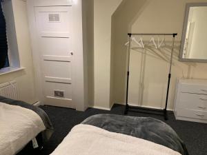 1 dormitorio con 1 cama y armario con puerta en Lovely Contractor Family House London, en Londres