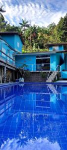 a large blue swimming pool in front of a building at Pousada restaurante recanto do Marimar in Paraty