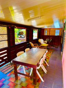 - une salle à manger avec une table et des chaises en bois dans l'établissement Teraupoo Lodge Maison, à Afareaitu
