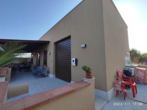 Casa con patio con sillas rojas en House & Garden, en Rilievo