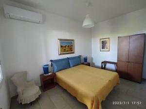 1 dormitorio con 1 cama amarilla y 1 silla en House & Garden, en Rilievo