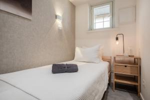 - une petite chambre avec un lit blanc et une fenêtre dans l'établissement Betsalel's Studio, à Jérusalem