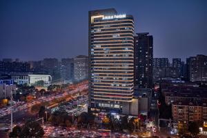 Fairfield by Marriott Changsha Tianxin في تشانغشا: مبنى طويل في مدينة في الليل مع حركة المرور