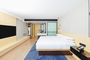 ein Schlafzimmer mit einem großen Bett und einem Flachbild-TV in der Unterkunft Fairfield by Marriott Changsha Tianxin in Changsha