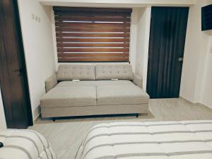 un sofá en una habitación con ventana en Habitación privada Centro Expositor 5-A, en Puebla
