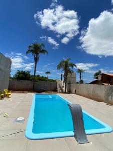 uma piscina azul num quintal com palmeiras em Pousada Barra Coast em Barra Velha