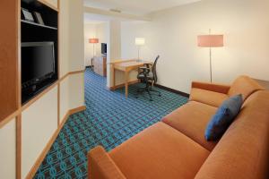 a living room with a couch and a desk at Fairfield Inn & Suites Indianapolis Airport in Indianapolis
