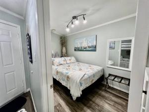 Casa Del Marlin - Your Beach Retreat on Galveston Island, TX في جالفيستون: غرفة نوم صغيرة مع سرير ومرآة