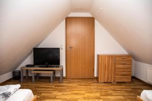 a room with a door and a table with a television at Ferienwohnungen Saida Wohnung 12 in Norden +15 photos