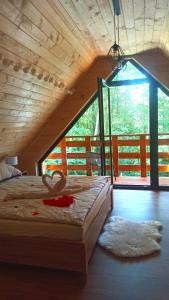 a large bed in a room with a large window at Las Lorien - wynajem domków letniskowych 2.0 in Roczyny