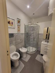 een badkamer met een douche, een toilet en een wastafel bij Panormus Apartment in Palermo