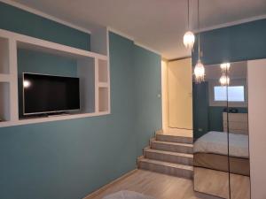 een kamer met een trap met een tv aan de muur bij Panormus Apartment in Palermo