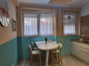 een kleine keuken met een witte tafel en stoelen bij Panormus Apartment in Palermo