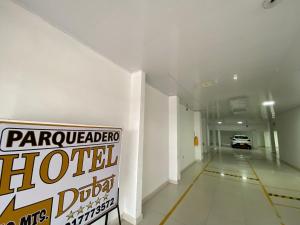 a white hallway with a car parked in a garage at Hotel Dubai Deluxe Curumani in Curumaní