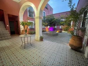 a courtyard with a table and potted plants in a building at Quinta La Perla in Guadalajara