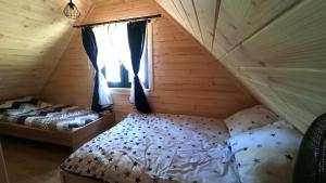 RoczynyにあるLas Lorien - wynajem domków letniskowych 2.0の木造キャビン内のベッドルーム1室(ベッド2台付)