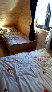 a bedroom with a bed in a wooden cabin at Las Lorien - wynajem domków letniskowych 2.0 in Roczyny