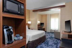 a hotel room with a bed and a flat screen tv at Fairfield Inn & Suites by Marriott Augusta Washington Rd./I-20 in Augusta