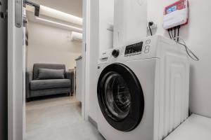 uma máquina de lavar roupa num quarto com uma cadeira em At Kidan's em Jerusalém