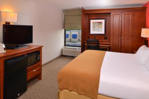 a hotel room with a bed, television and a desk at Holiday Inn Express Crestwood, an IHG Hotel in Crestwood