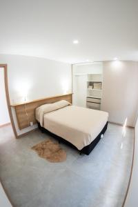 1 dormitorio con cama y espejo en CostaZen, en Piriápolis