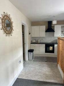 a kitchen with white cabinets and a mirror on the wall at Charming 2-Bedroom Retreats in Axminster