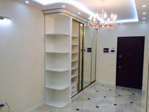 a room with white shelves and a chandelier at The Park Azure Residence - Baku in Baku