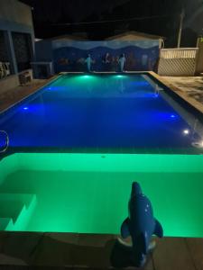 - une piscine avec un éclairage bleu et vert dans l'établissement Casa mobiliada para descanso e com piscina para o lazer há 5 min do aeroporto, à Bayeux