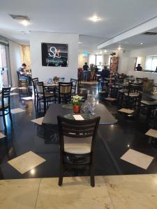 a dining room with tables and chairs in a restaurant at Harmonia Flat's - Aeroporto Gru in Guarulhos
