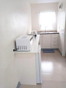eine weiße Küche mit einer Mikrowelle auf der Theke in der Unterkunft Lelago Eco Lodge in Apia