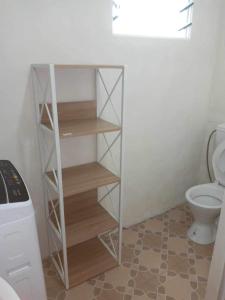 een badkamer met een toilet en een boekenplank bij Lelago Eco Lodge in Apia