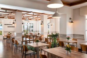 a restaurant with wooden tables and chairs and windows at Marriott's Playa Andaluza in Estepona